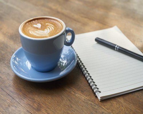 A warm cup of coffee and notebook in the morning light